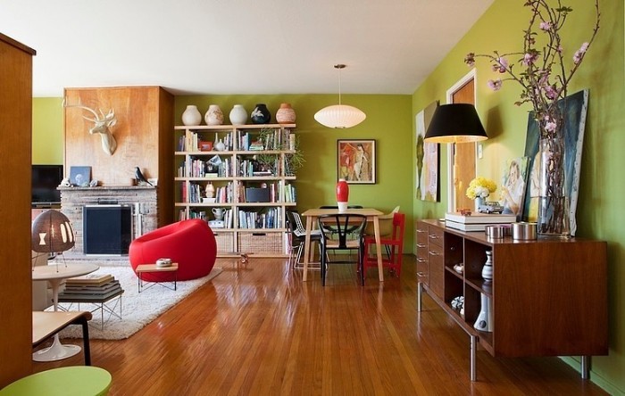A Mid-Century Modern living room with green walls and wooden floors.