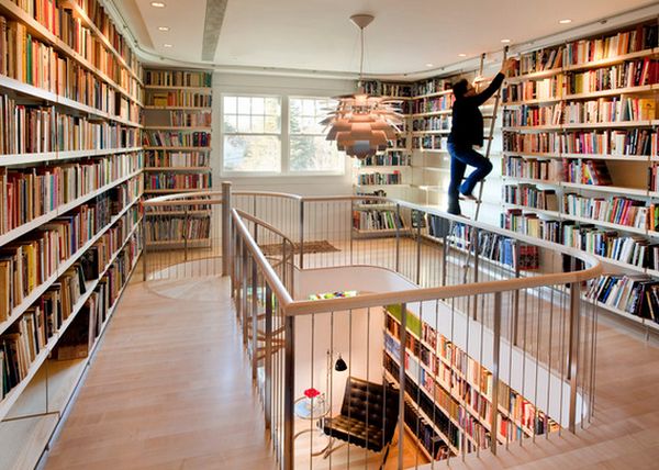 A beautiful library with bookshelves and a person on a ladder.