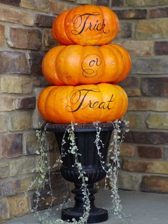 Three custom carved pumpkins stacked on top of each other.