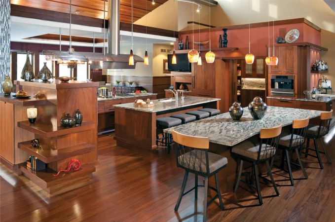 An open kitchen with a large island and bar stools.