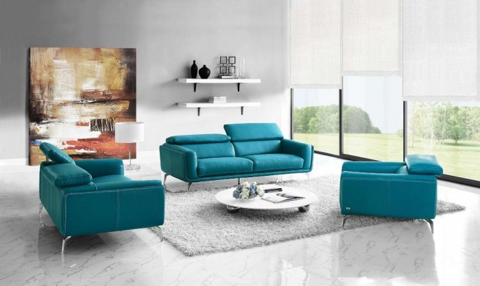 A living room with a teal leather couch and coffee table.