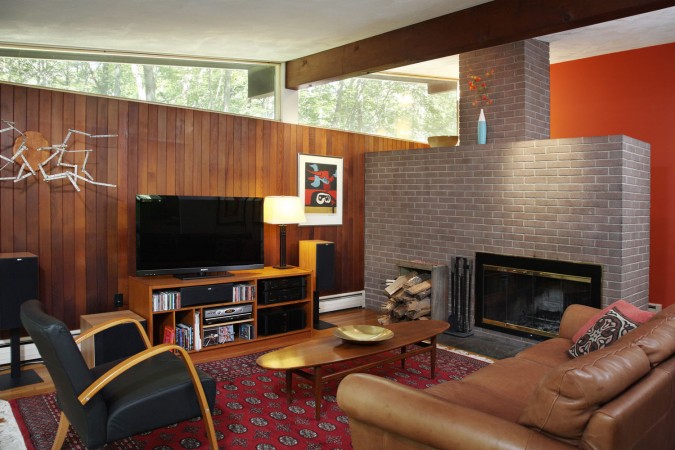 A Mid-Century Modern living room with a fireplace and a tv.