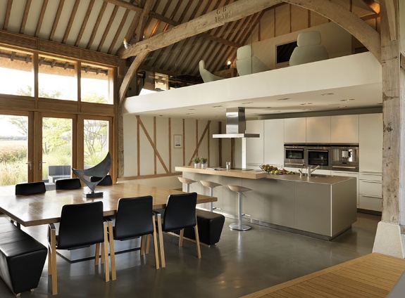 An open kitchen and dining area in a barn featuring mesmerizing home mezzanine.