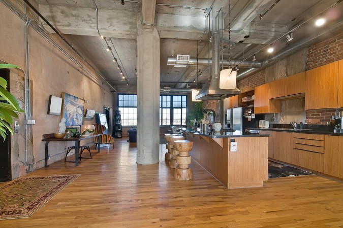 An industrial loft with an open kitchen and living room.