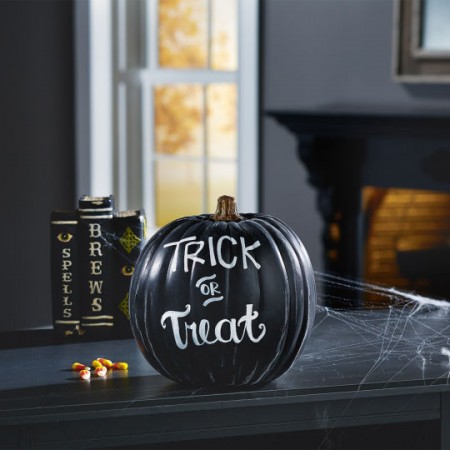 A custom carved pumpkin with the words trick or treat on it.