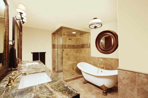 An elegant bathroom featuring a clawfoot bathtub, sink, and mirror.