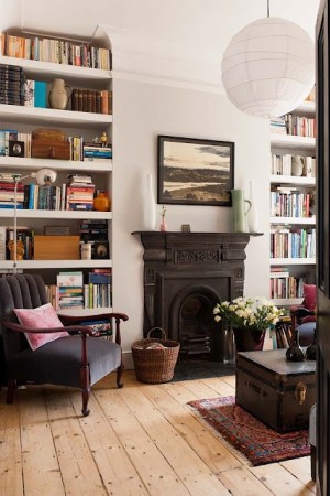 A private living room with a beautiful fireplace and bookshelves.