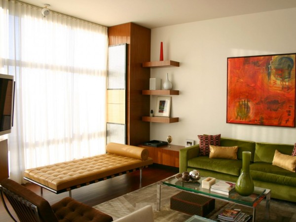 A mid-century modern green couch in a living room.