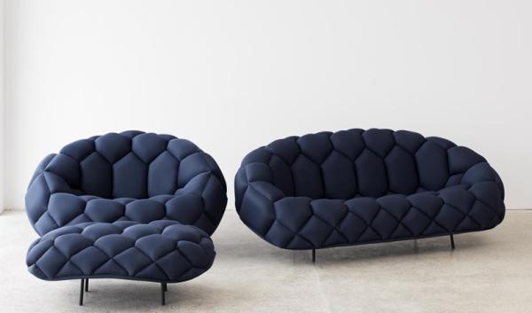 Three fun blue sofas in front of a white wall.