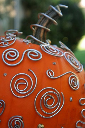 A custom carved pumpkin decorated with wires.