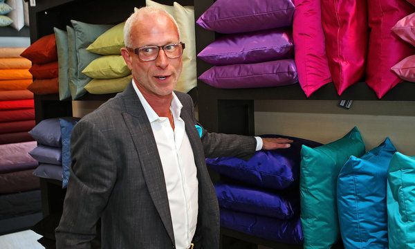 Jamie Drake's designer focus brings a man standing in front of a display of colorful pillows to life.
