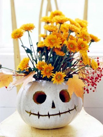 A custom carved pumpkin with yellow flowers sits on a chair at Michaels.