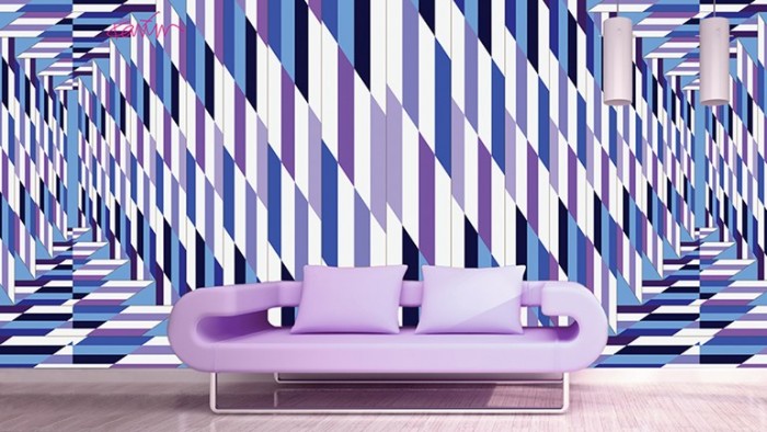 A purple sofa in front of a blue and purple striped wall showcasing optical art.