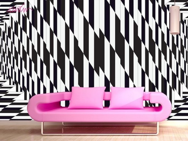 A pink couch against a black and white striped wall, inspired by optical art.