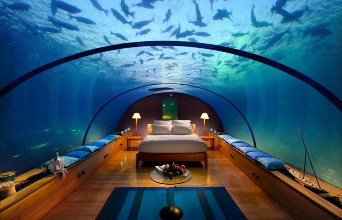 A bedroom with an aquarium bed under the ocean.
