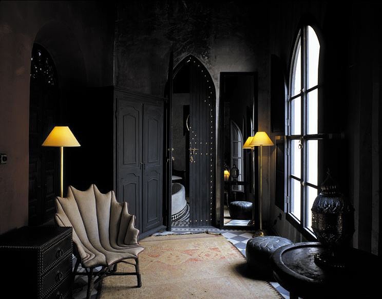 A dark room with black walls and a chair, inspired by Halloween.