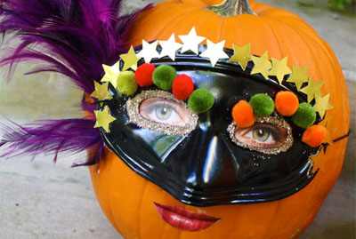 A woman wearing a mask on a custom carved pumpkin at Michaels.