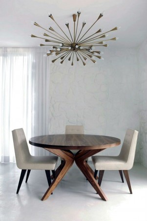 A mid-century modern dining room with a wooden table and chairs.