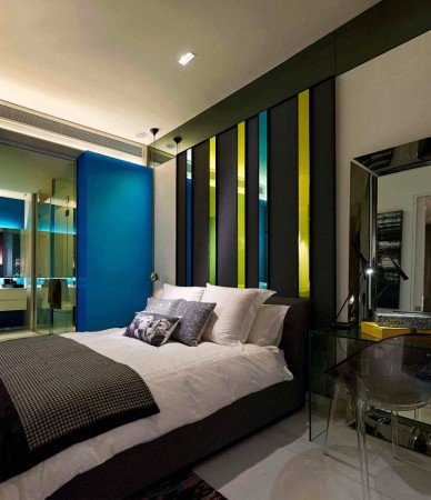 A bedroom with a bed and a vertical bedside table.