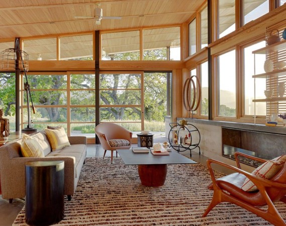 A living room with large windows and wooden walls in Mid-Century Modern Style.
