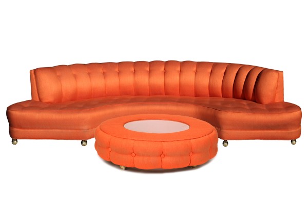 An orange sectional sofa with a unique ottoman design.