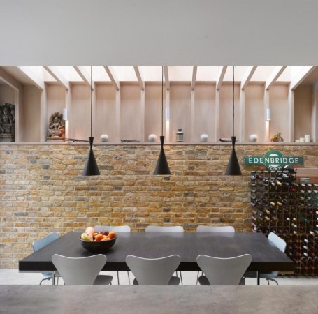 A modern kitchen with a brick wall and a table, highlighting how to make stone walls work inside your home.