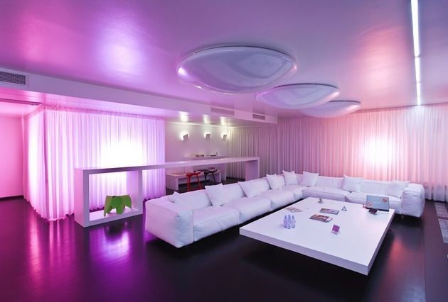 A living room is illuminated with purple and pink lights.