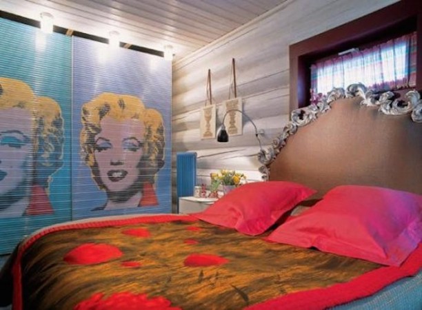 A pop art-inspired bedroom with Marilyn Monroe painted on the wall.
