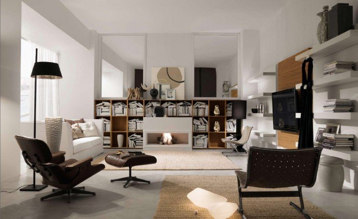 A vertical living room with white furniture and bookshelves.