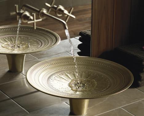 A bathroom with two gold vessel sinks.