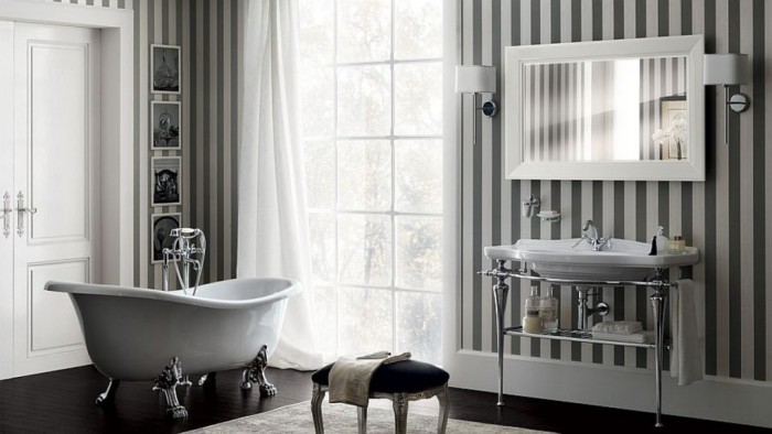 A bathroom with black and white striped walls showcasing the elegance of the clawfoot bathtub.