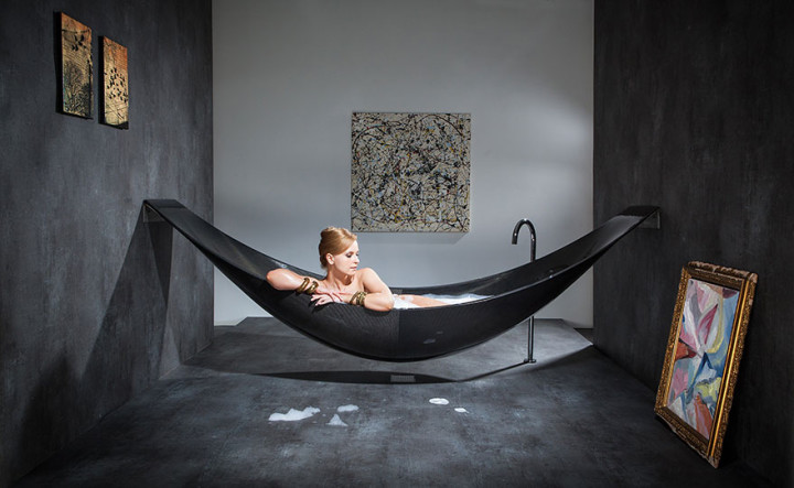 A woman relaxing in a hammock in a bathtub.