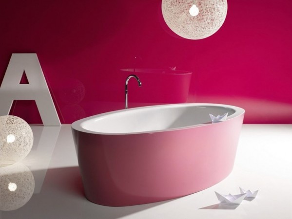 A pink bathroom with a bathtub.