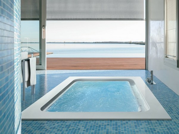 A bathroom with a view of the ocean featuring a bathtub.