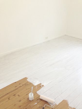 A room with painted white floorboards.