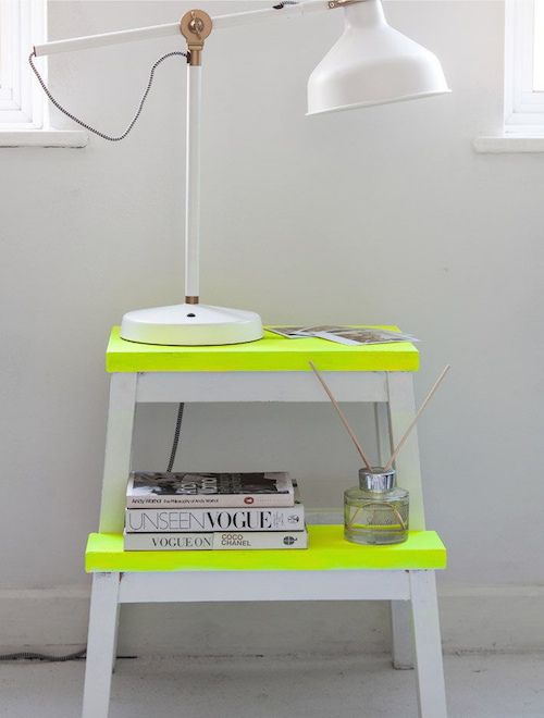 A yellow step stool with a lamp on top, perfect for decorating your home.