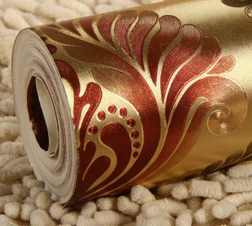 A roll of metallic wallpaper with gold and red hues for dimension and shimmer.