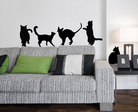 A living room with wall stickers of cats.