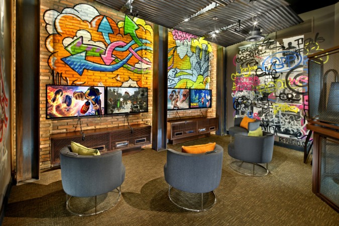 A room with graffiti on the corrugated metal walls and chairs.