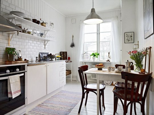 A white kitchen with painted white floorboards.
