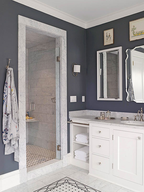 A bathroom with blue walls and white counter tops showcasing luxury walk-in shower.