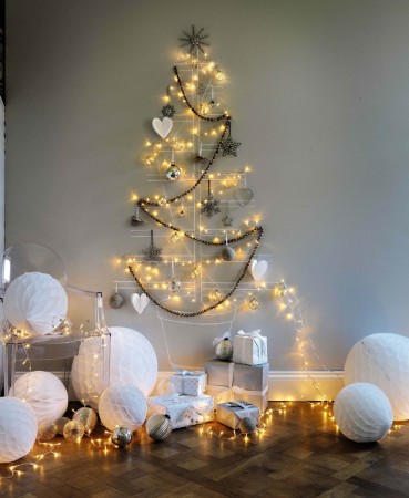 A white Christmas tree decorated with white balls and lights.
