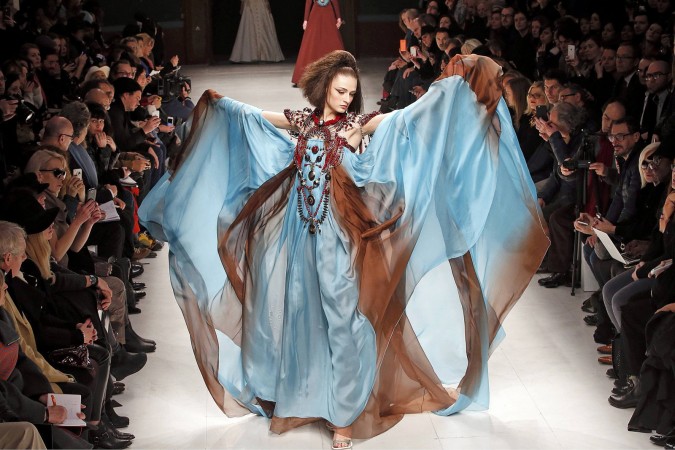 A woman in haute couture walks down the runway.