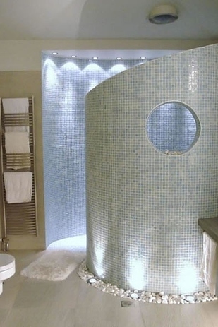 A luxurious walk-in shower with blue tiles.