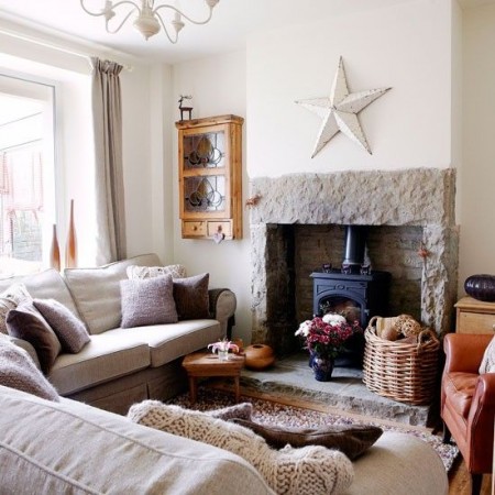 A living room with a stone fireplace and cozy couches, recreating the charm of a rustic home.