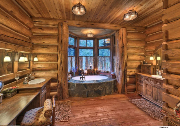 A rustic log cabin bathroom featuring a tub and sink.