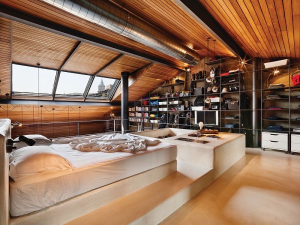 An attic bedroom with a bed and bookshelves designed in a Masculine Industrial Style.