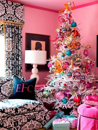 A pink living room with a colorful Christmas tree decorated in alternative colors.