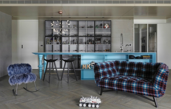 A kitchen with a blue plaid chair and blue cabinets.