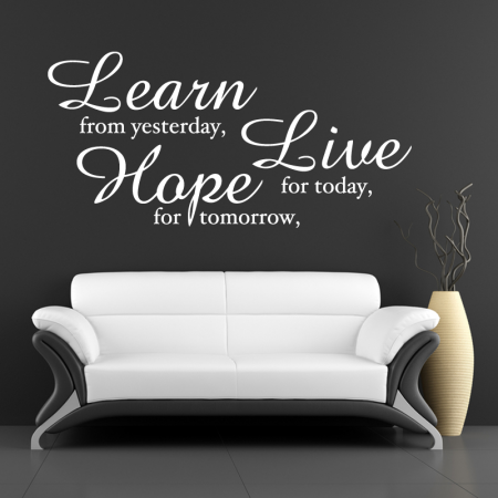 A white couch against a black wall, adorned with wall stickers.